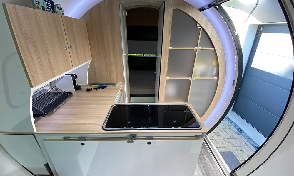 Like the 3X trailer, the 3XC truck camper has a central L-shaped kitchen just inside the entryway
