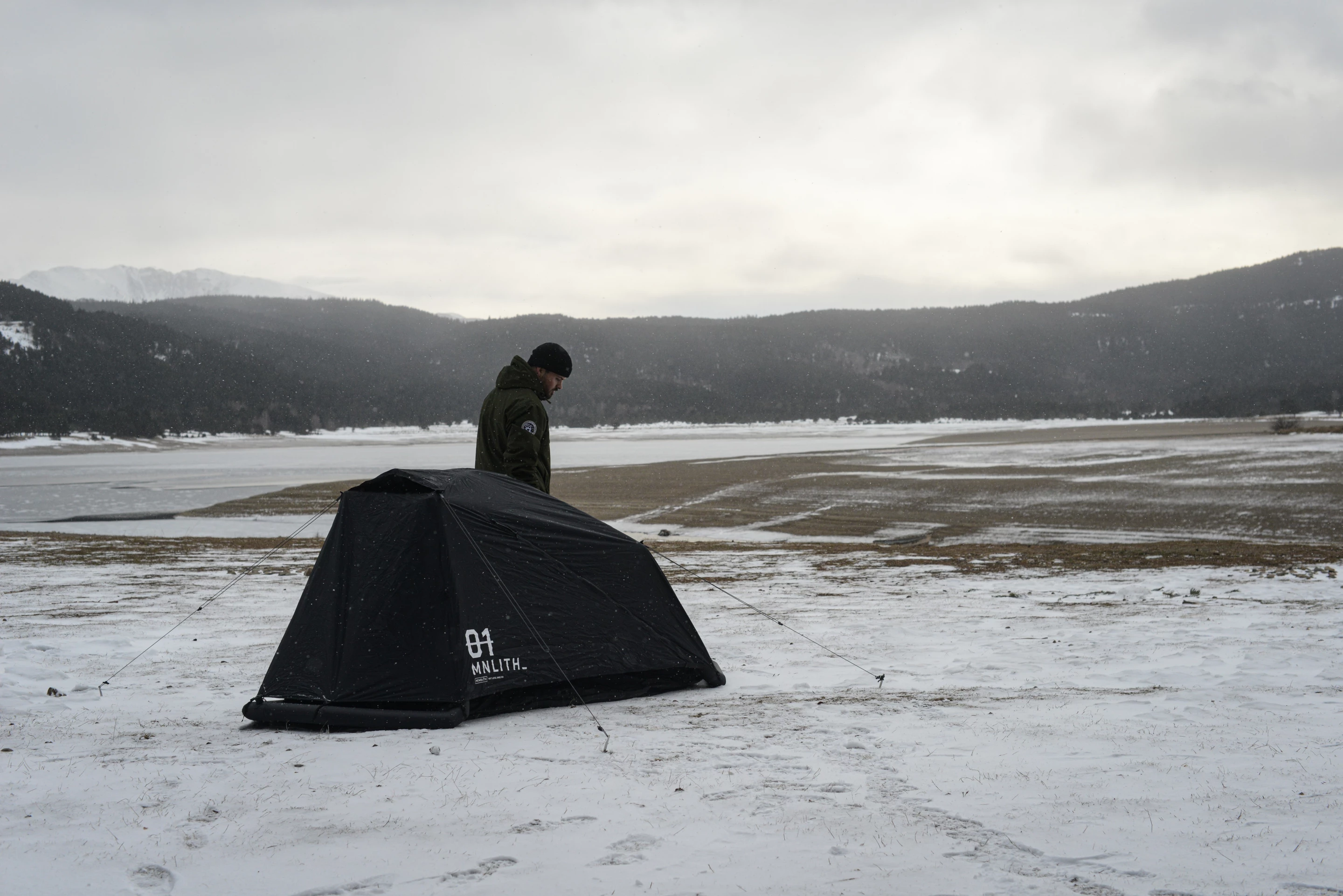 The main tent kit is ready to pitch on the ground with an inflatable frame, guy lines, a rain fly and stakes