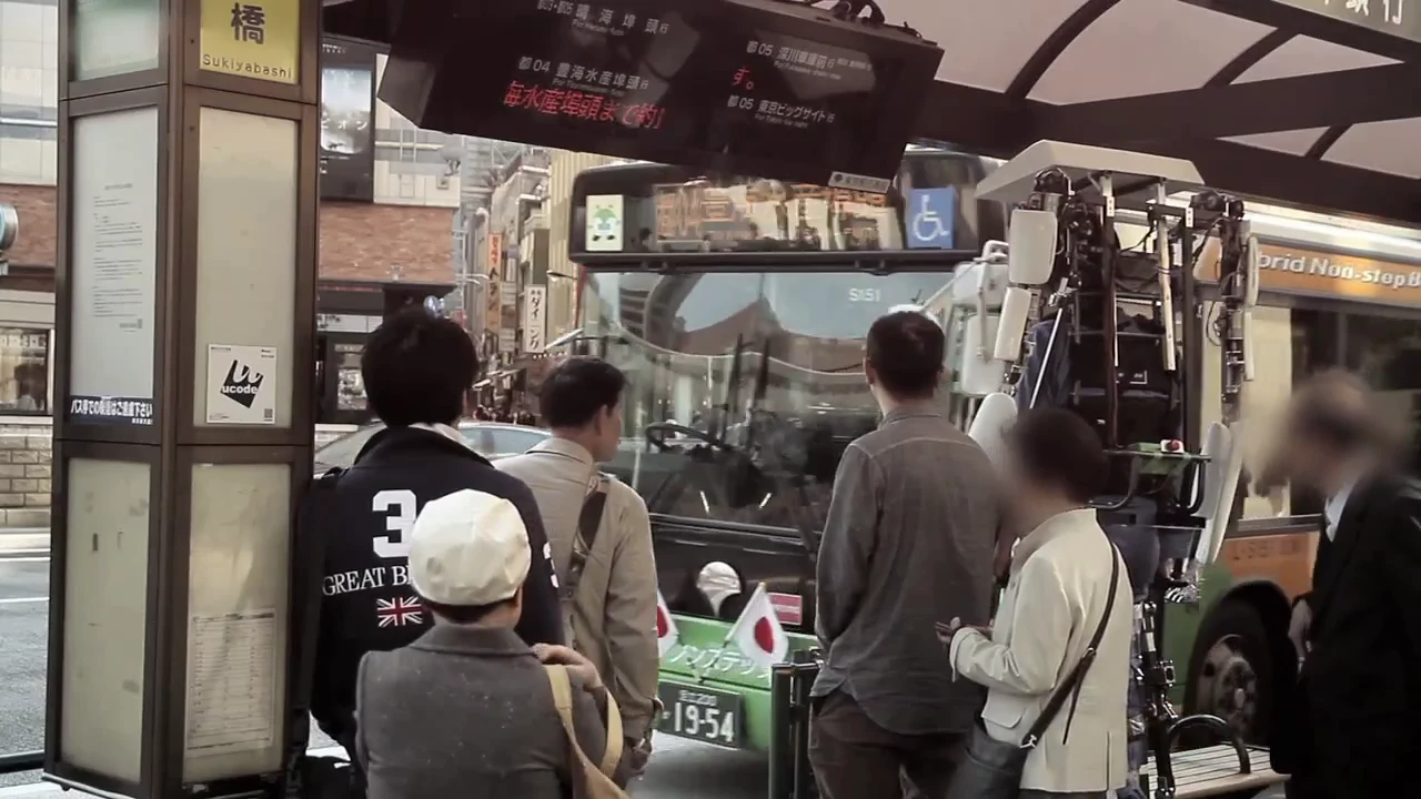 The Power Jacket MK3 looms over a crowd waiting for the bus