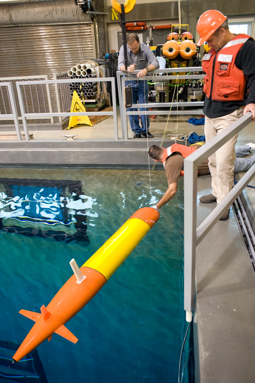 Jim Bellingham, Thomas Hoover, and Bret Hobson work on the long-range AUV in the MBARI test tank (Image: Todd Walsh copyright 2010 MBARI)