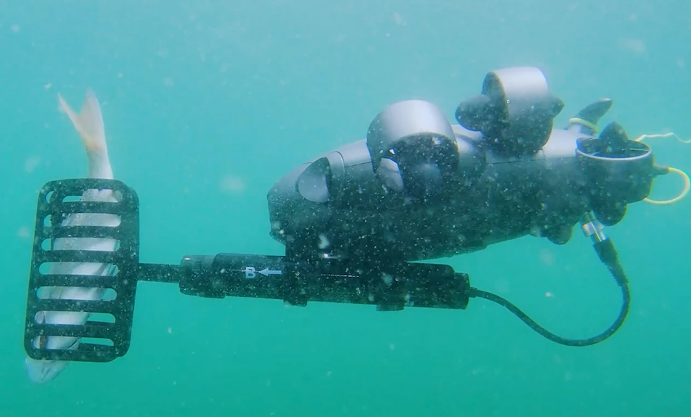 The FiFish V6 Expert uses its optional "mort remover" tool to remove a dead fish from a fish farm