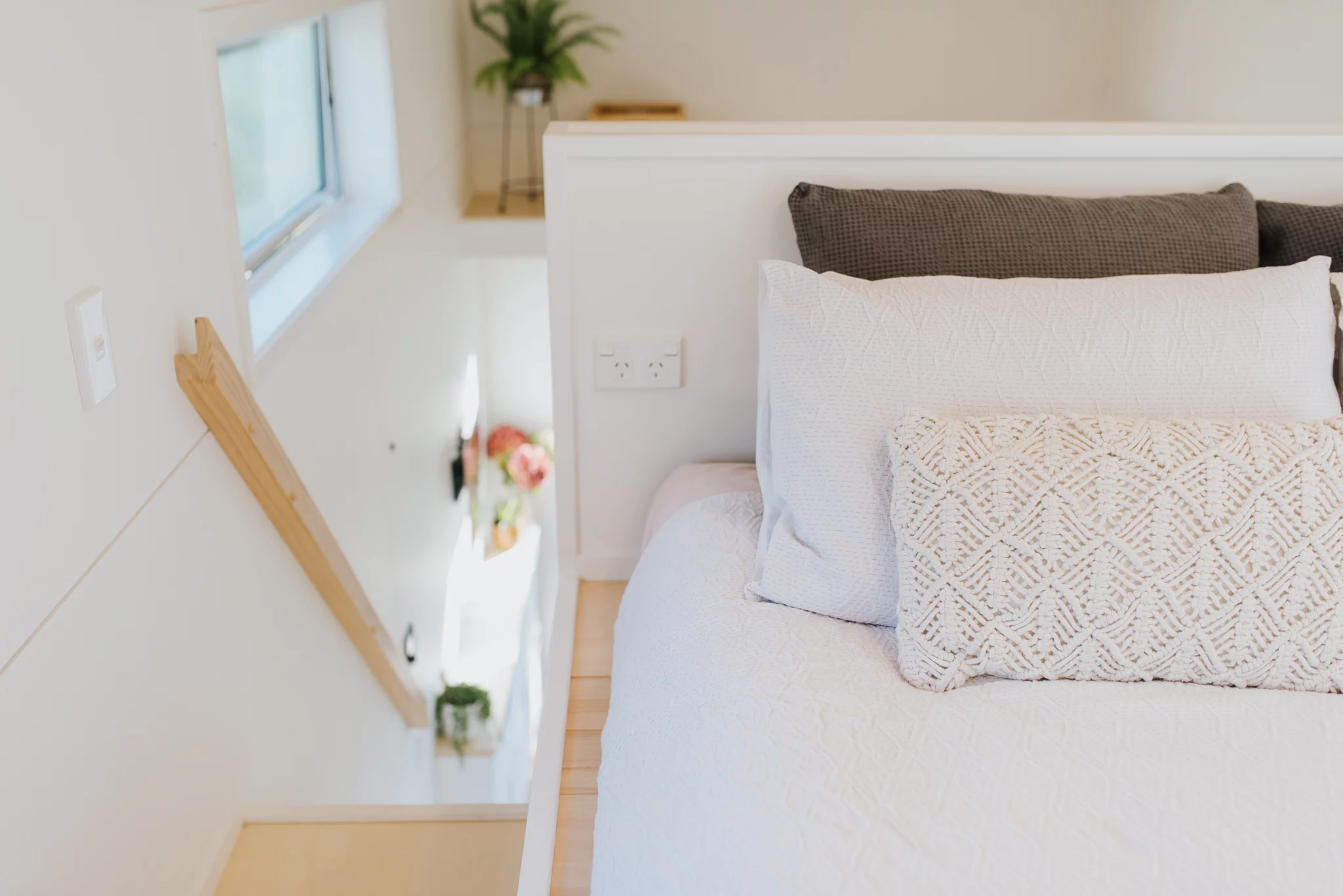 The Bitser Tiny House's one bedroom is accessed by storage-integrated staircase