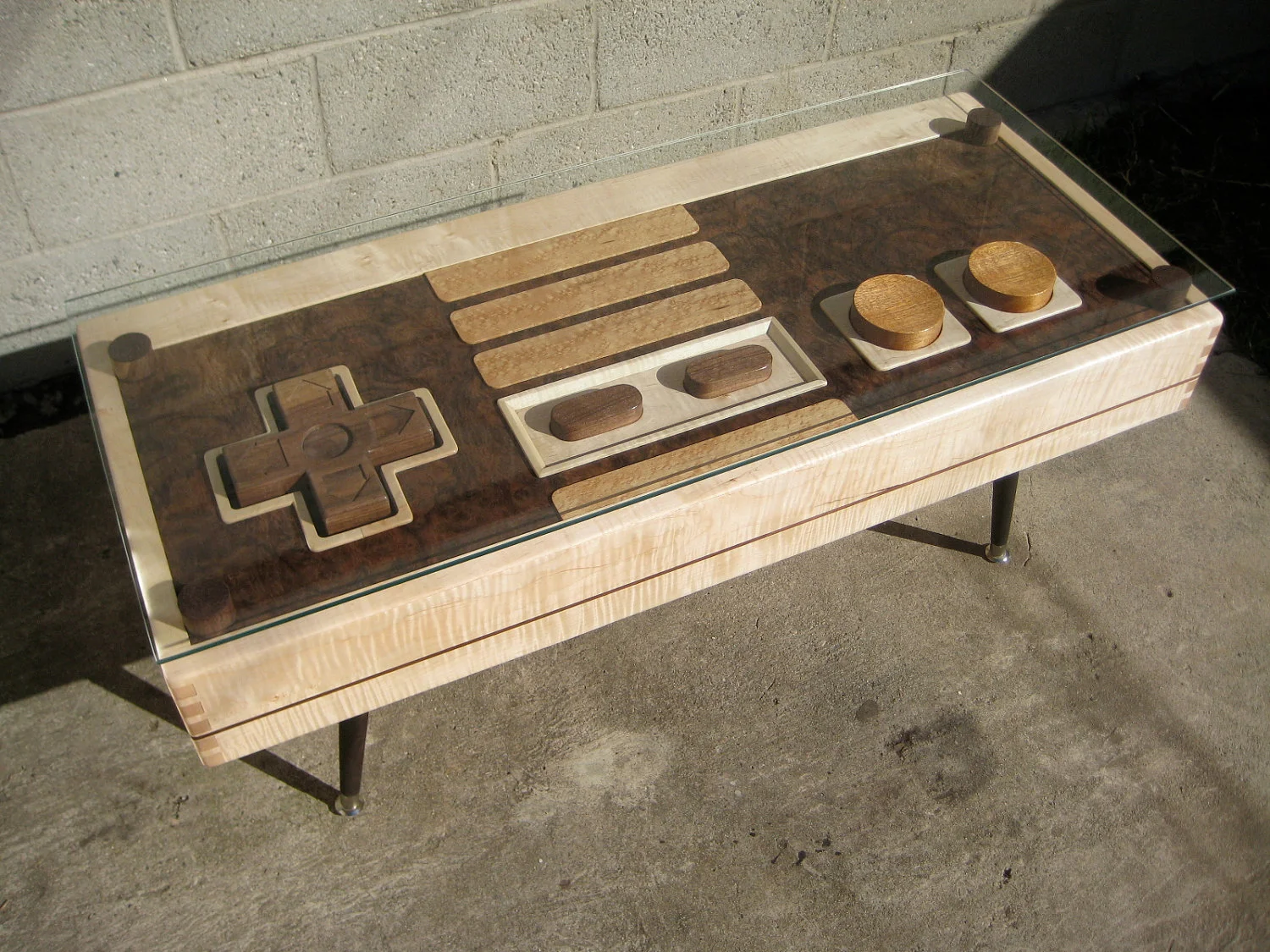 When not being used to control the onscreen action of favored NES classics like Super Mario, the table's huge wooden four-way directional pad and action buttons sit underneath a removable glass top