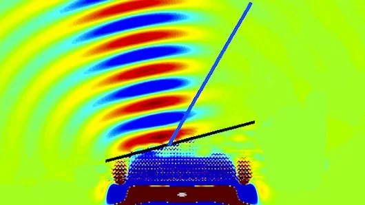 A prism made of the Stanford metamaterial shows negative refractive index by refracting a beam of light backwards compared to how a normal prism would (blue line) (Photo: Stanford University)