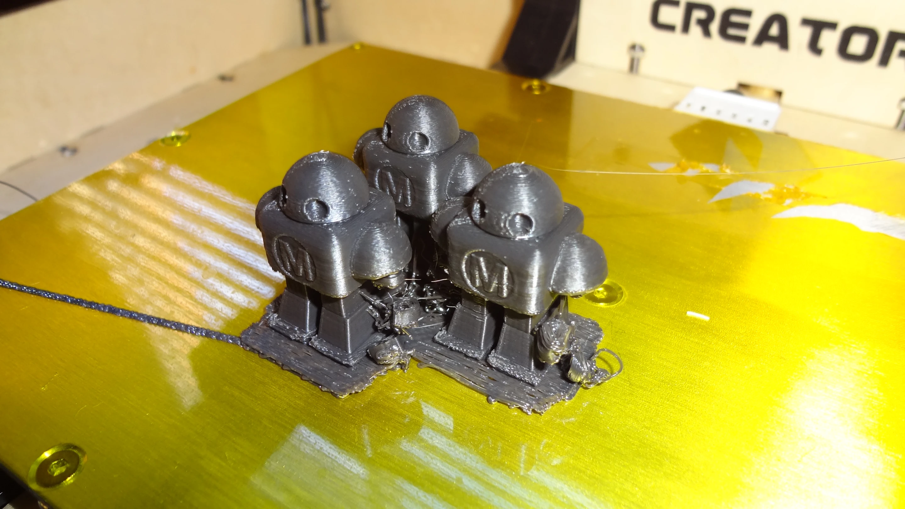 Showing some of the detail possible with this printer, these tiny robots are just about an inch (30 mm) tall. Note that the hands have fallen off because did not tell the printer to include supports (Photo: Gizmag)