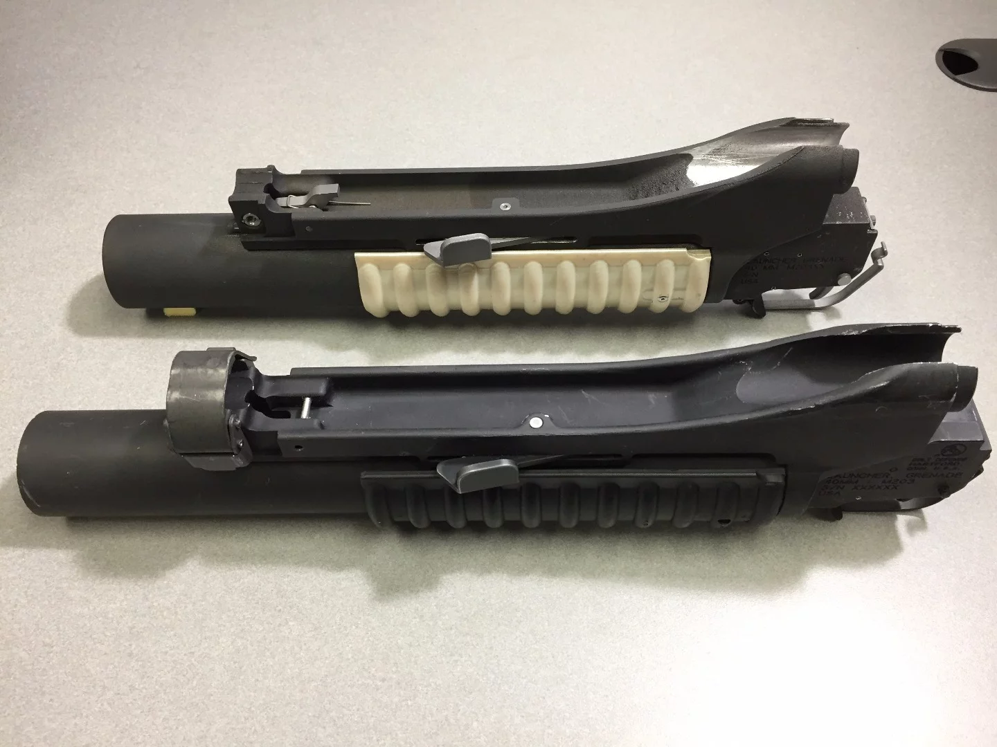 More than 90 percent of the components in the prototype grenade launcher, top, were printed with AM, in just 35 hours and on a single build plate