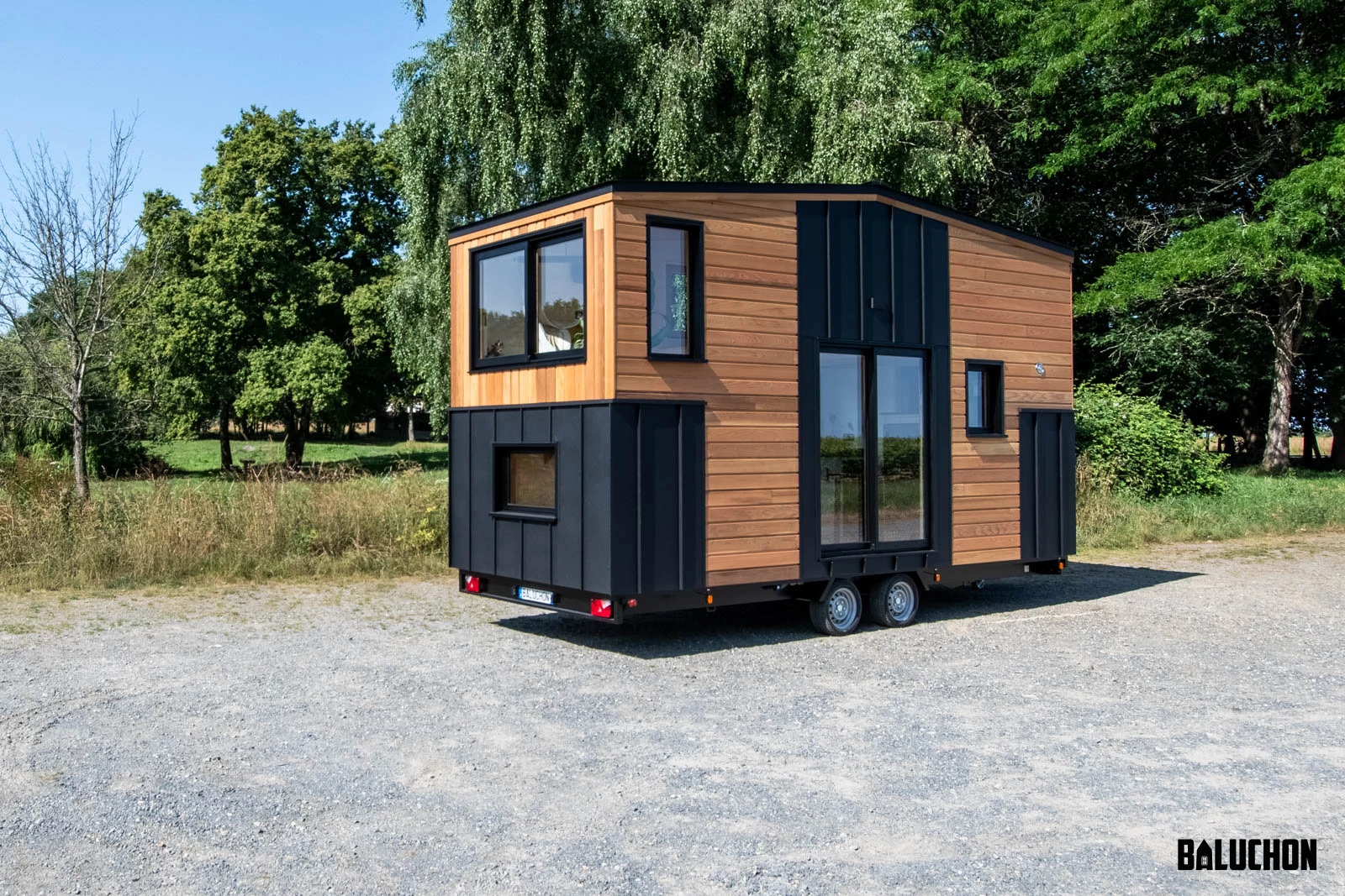 The Nouvelle Dans is finished in red cedar, with black metal accenting, and is topped by a metal roof