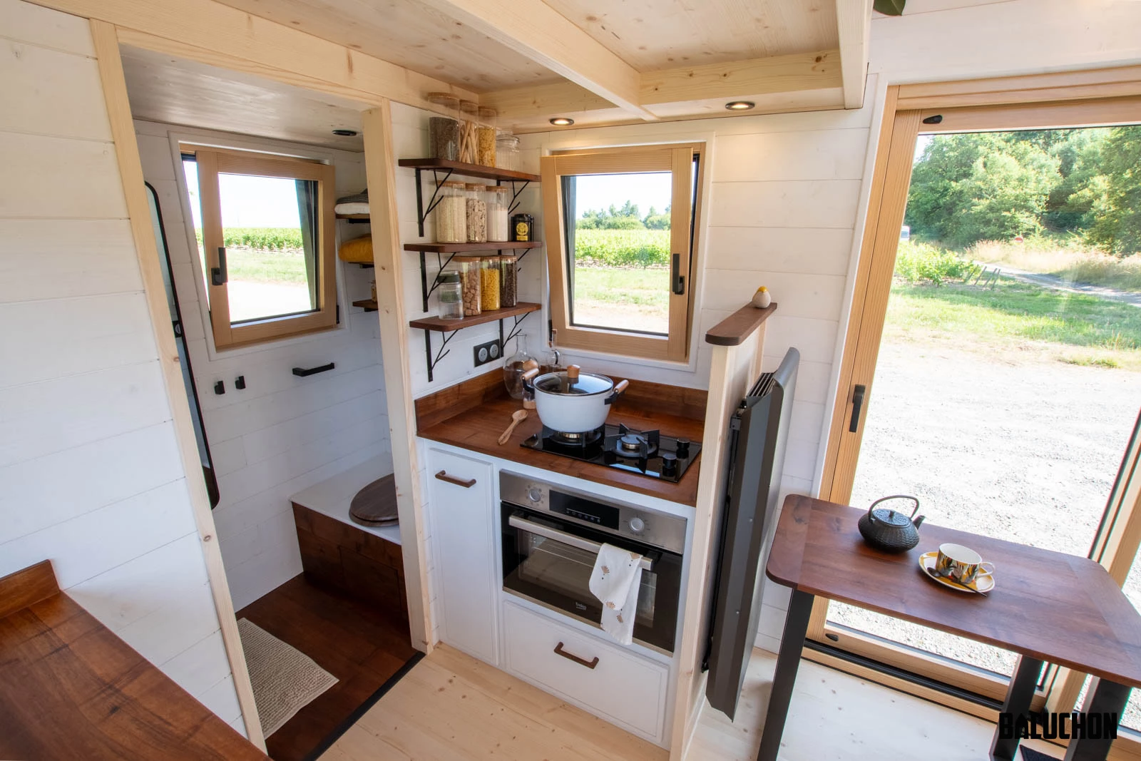 The Nouvelle Dans' kitchen includes a sink, fridge, an oven, and a propane-powered two-burner stove
