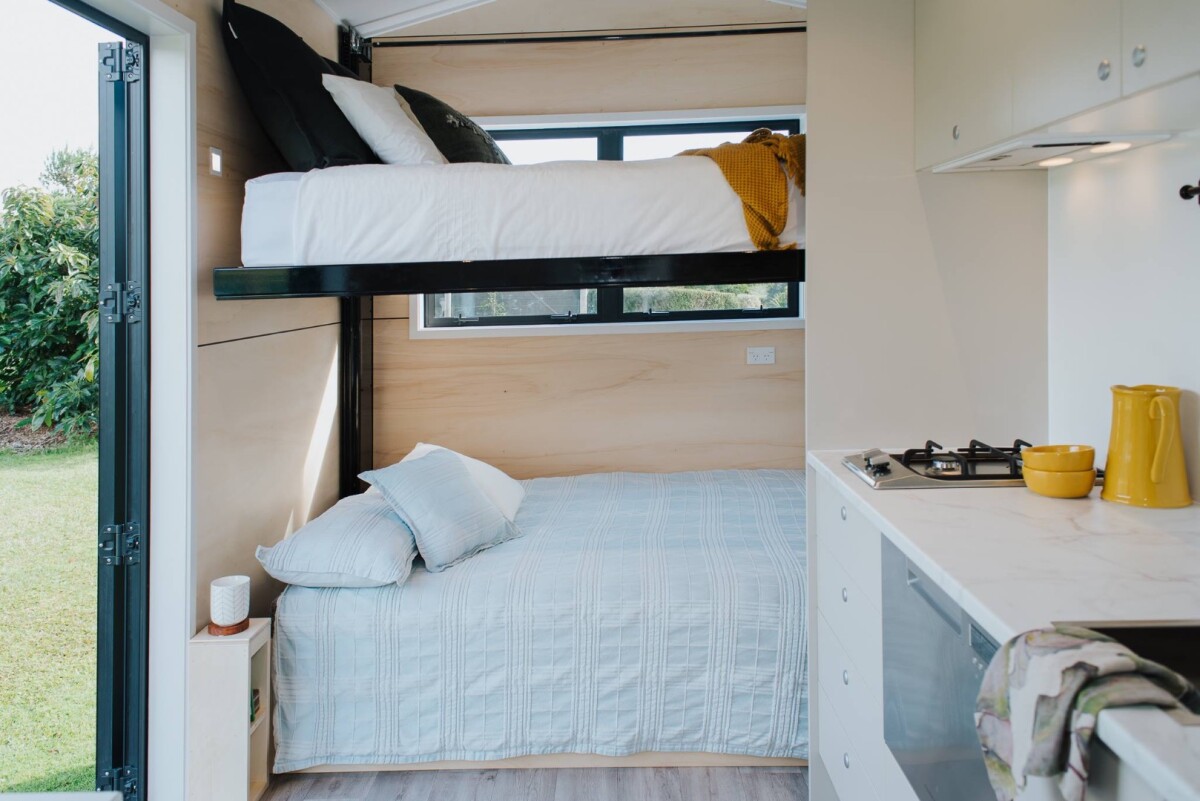 The Camper Tiny House's living/sleeping area has a neat pull-down bed that works on a counterweight
