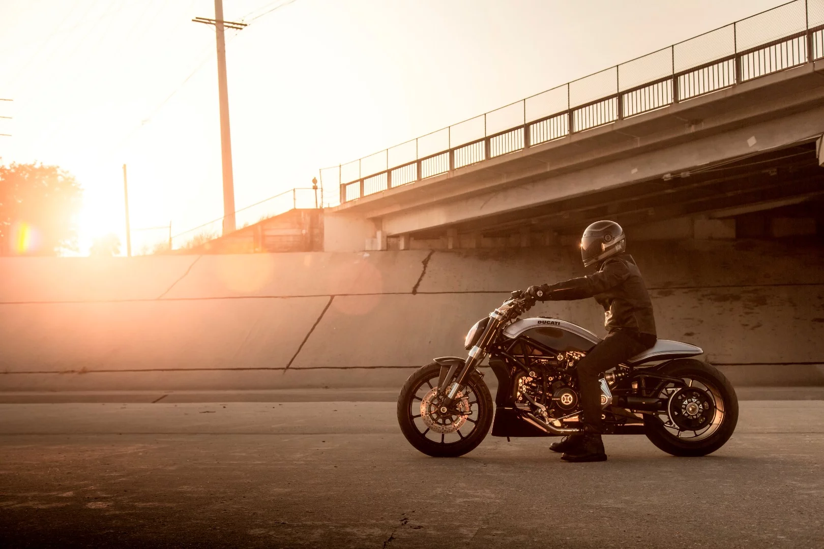 Man sits on Roland Sands XDiavel at sunset in aqueduct