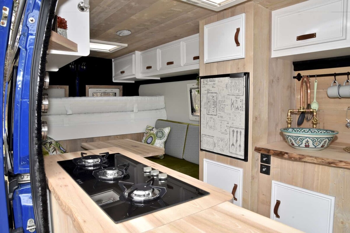 The triple-burner stove and refrigerator create a functional kitchen