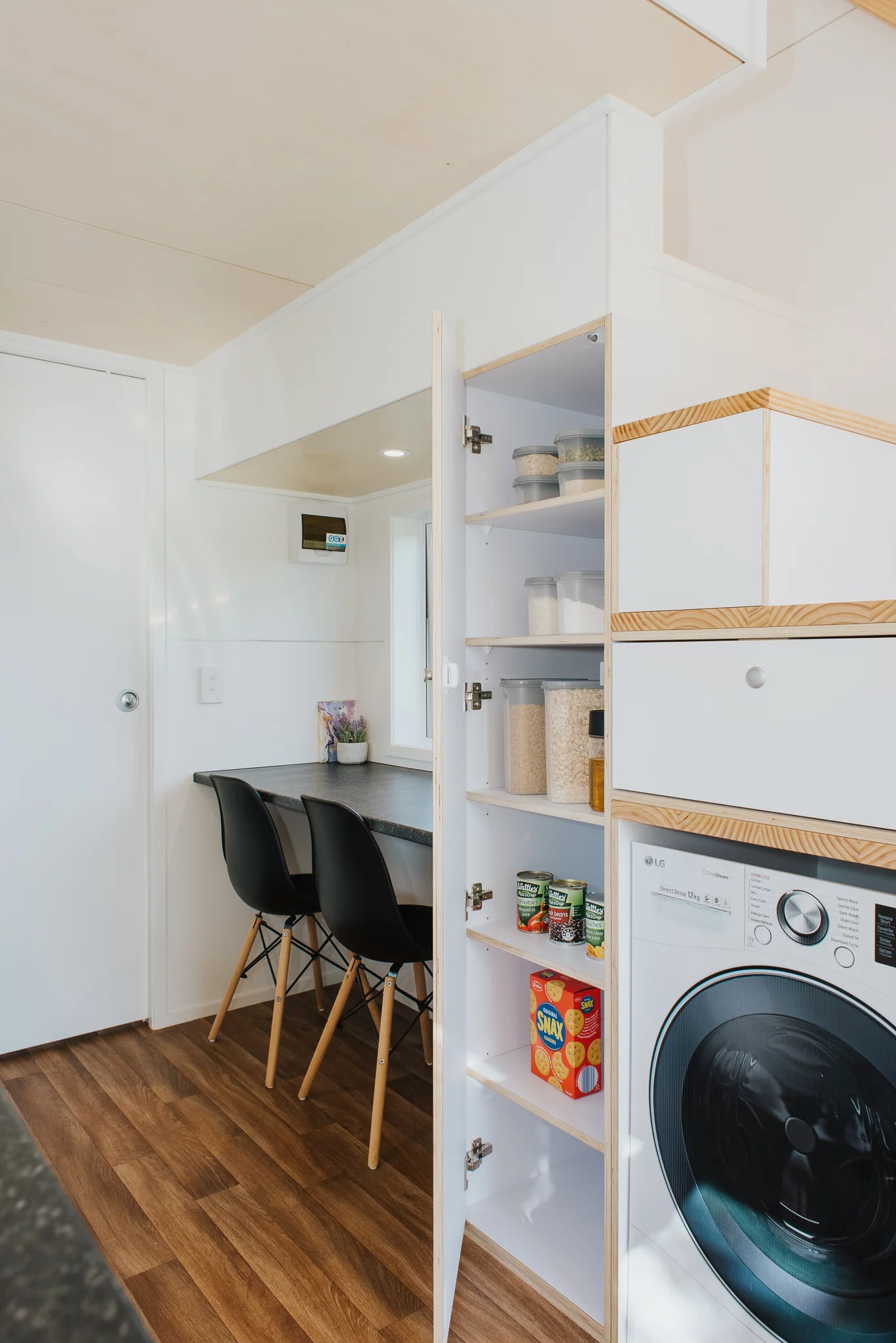 The Bitser Tiny House's storage-integrated staircase is home to a washing machine too