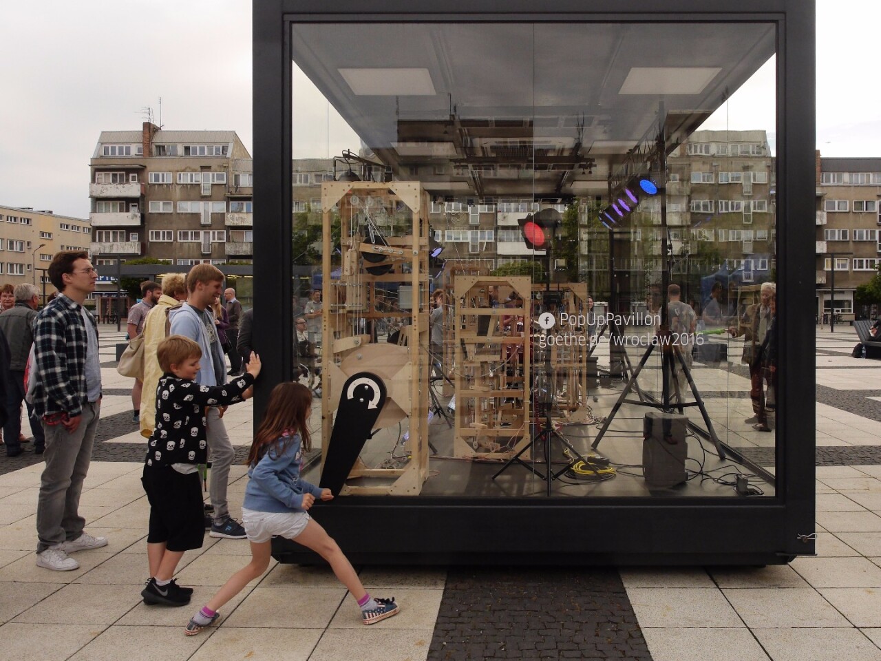 The musical cacophony is activated by a huge hand crank to the right of the transparent glass case