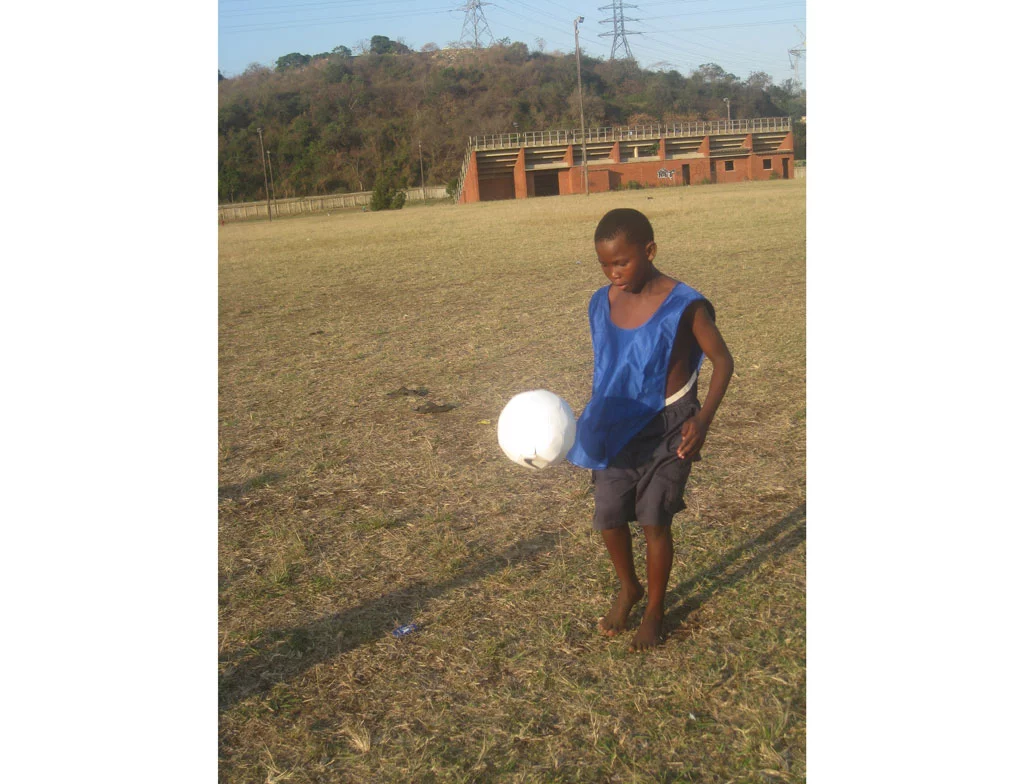 A young lad tests out the prototype sOccket power-generating soccer ball in a Durban, South Africa, trial of the device