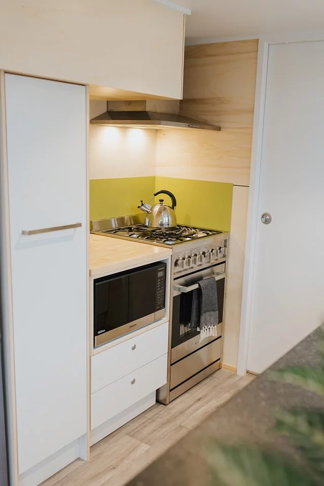The Green Hill Farm Tiny House's kitchen includes a propane gas-powered oven and four burner stove