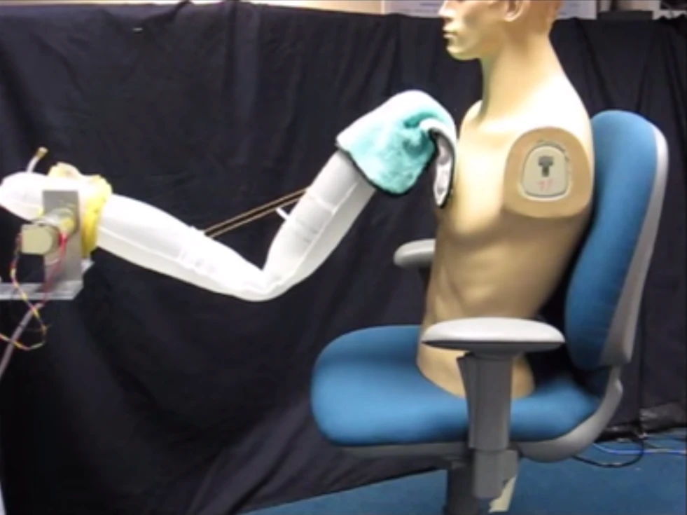 A soft robotic arm giving a mannequin a sponge bath