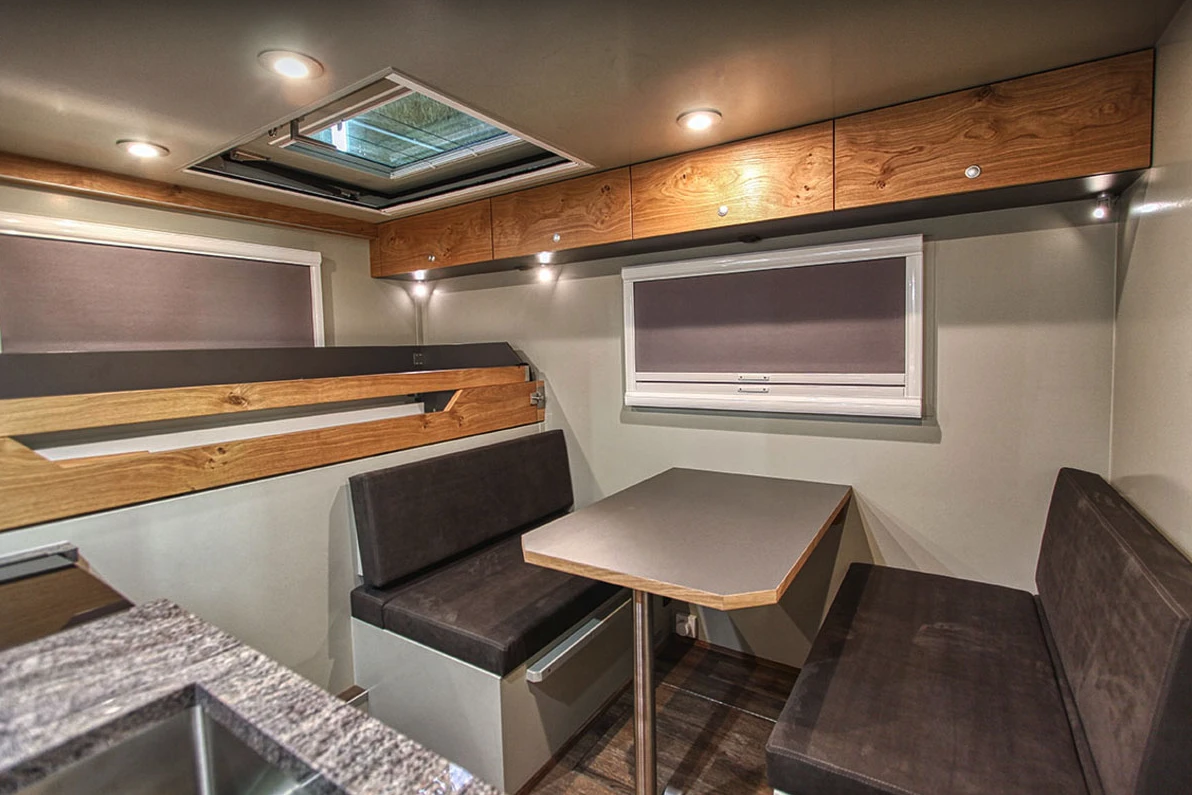 The dinette is located across from the kitchen, the slide-out bed in back