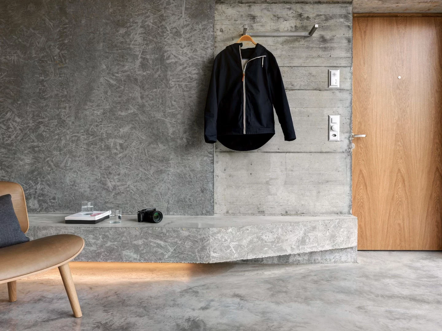 Affordable Housing Langgrütstrasse features simple furniture, including built-in shelving and benches