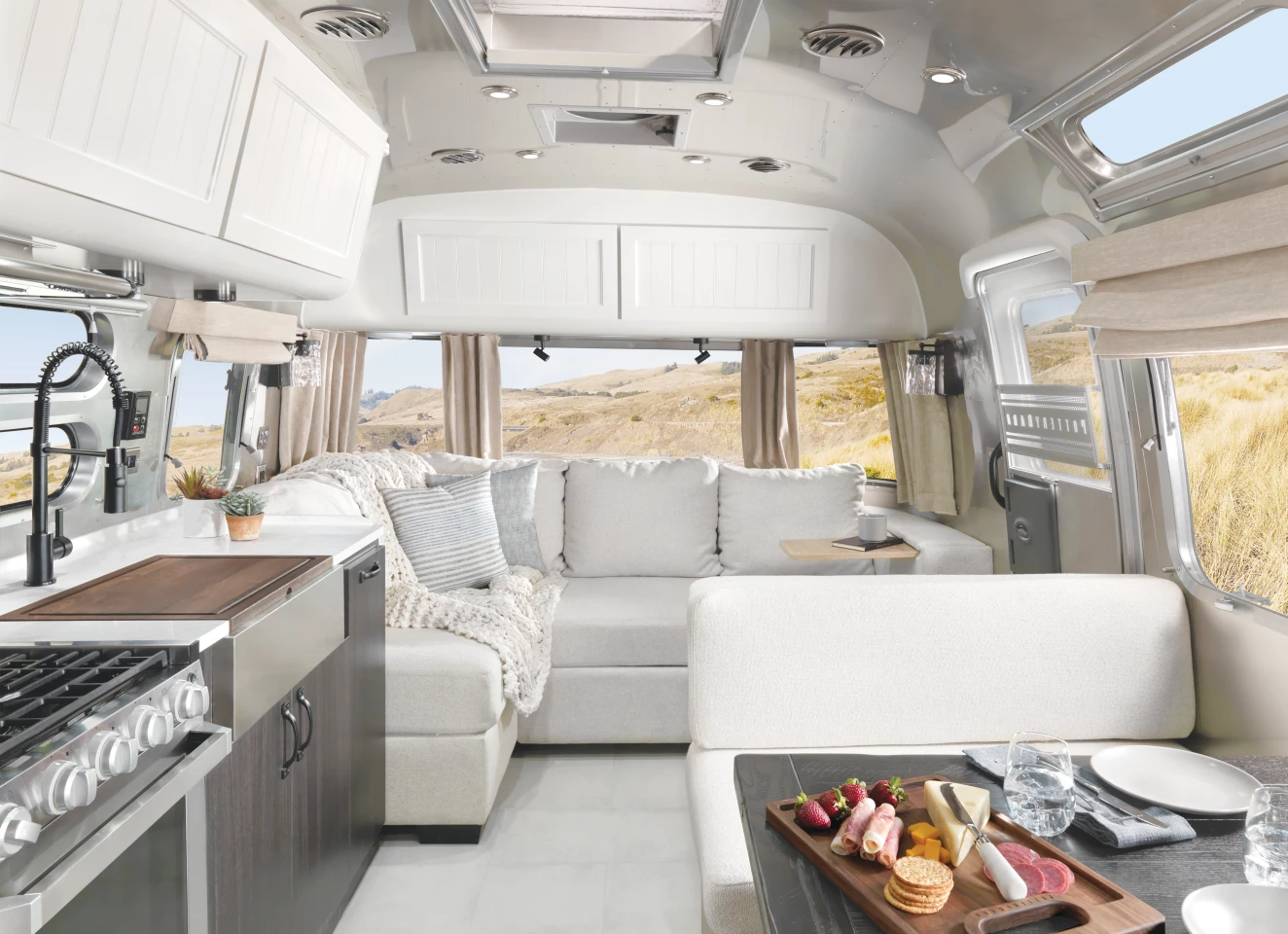 The Airstream Pottery Barn special edition trailer includes a front sofa lounge, central kitchen and dinette, dry bathroom, and rear bedroom
