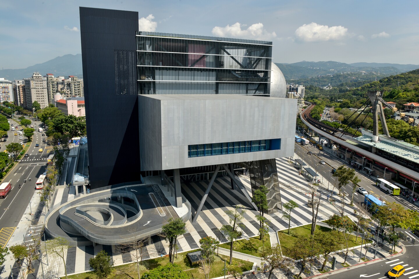 The Taipei Performing Arts Center is anchored by a central cube, which is raised above the ground to create a public plaza space