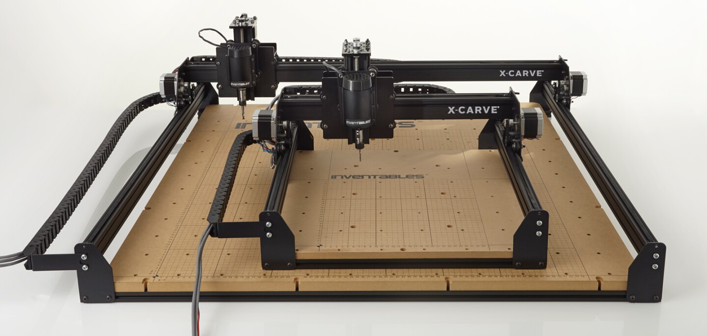 The two members of the X-Carve family, the regular sitting on top of the large model