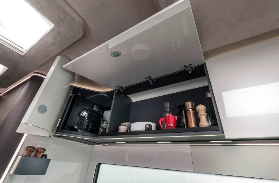 The coffeemaker in the corner drops down for use at the push of a button and retracts into the cabinet after use
