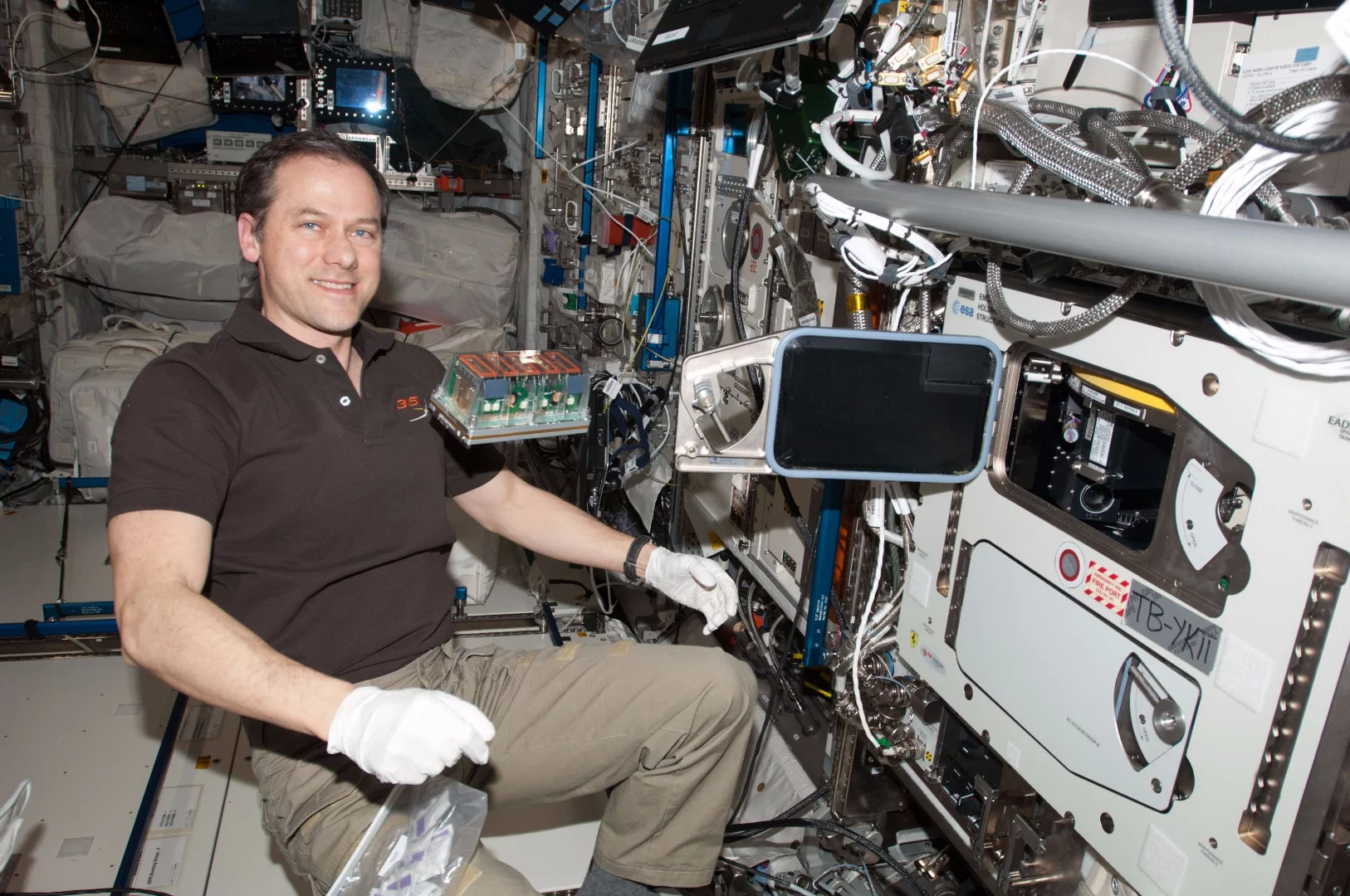 NASA astronaut Tom Marshburn, with a seedling cassette about to be loaded into the incubator