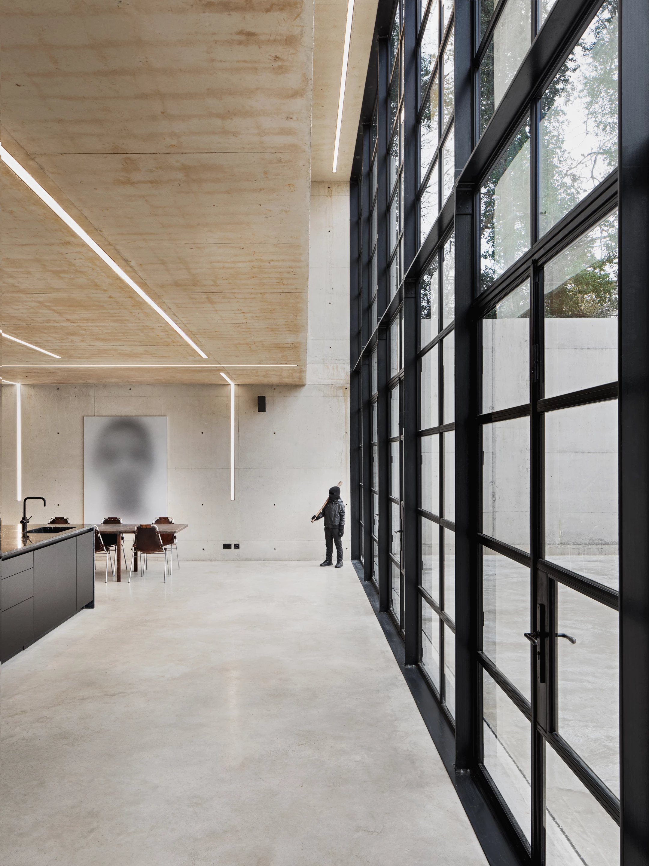 Ghost House's material palette is simple and consists of poured concrete, matte black steel and glass, with little in the way of furniture or greenery to soften it