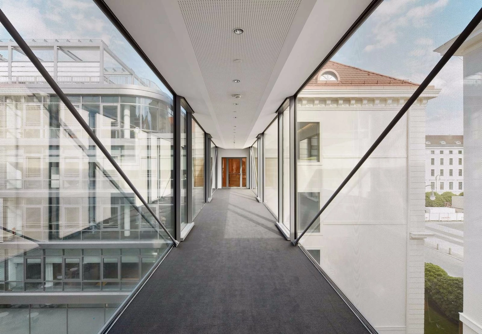 Expanses of glass along the footbridges provide views out over the building