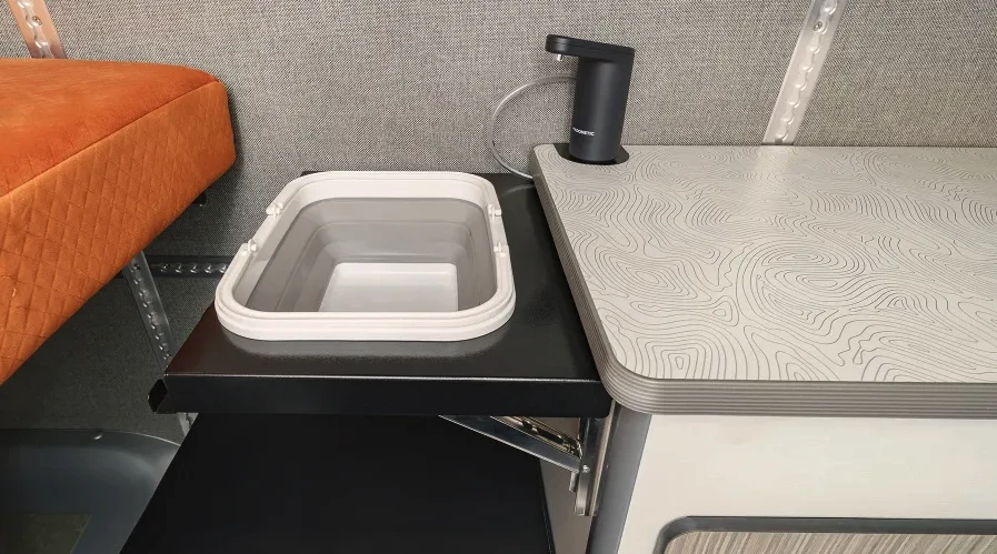 The Winnebago + Adventure Wagon camper van uses a modular sink with flip-up collapsible basin, Dometic HYD-WF magnetic faucet and HYD-J11 water canister