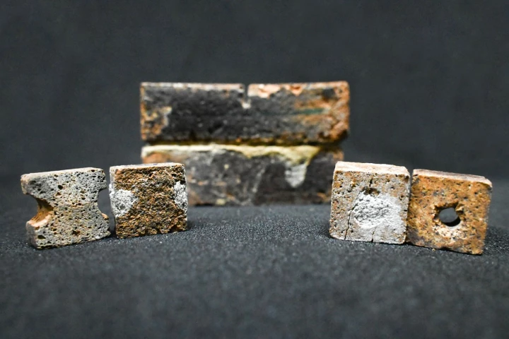 Bricks with artificially created flaws, alongside bricks repaired using the bacteria-filled slurry