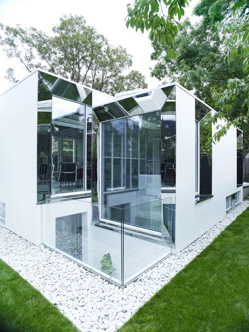 The exterior is dominated by white finished concrete, mirrors, and glass (Photo: Hélène Binet)