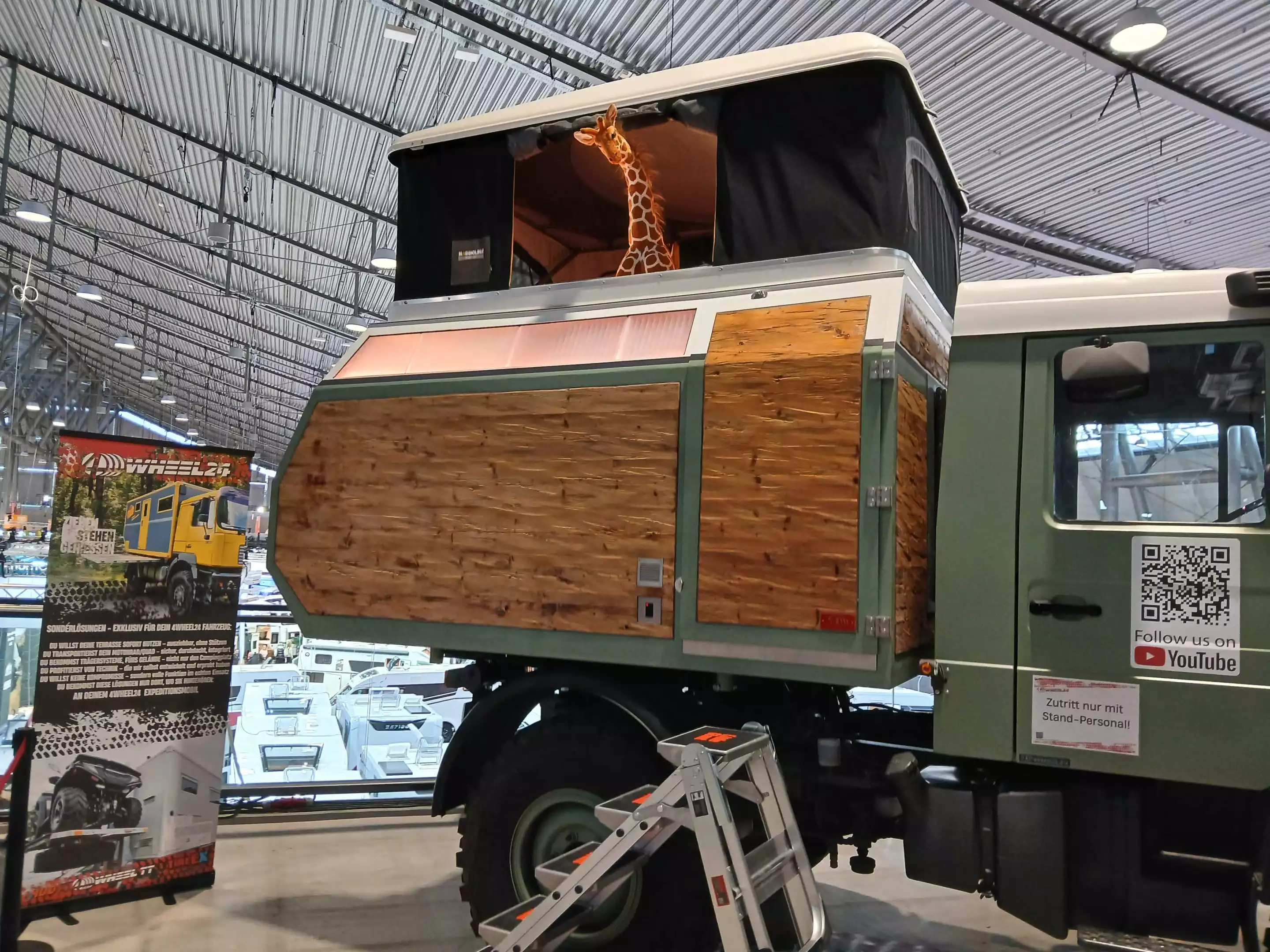 While the pop-up roof wears Autohome Maggiolina labels, the stuffed giraffe standing tall hints at the integrated design