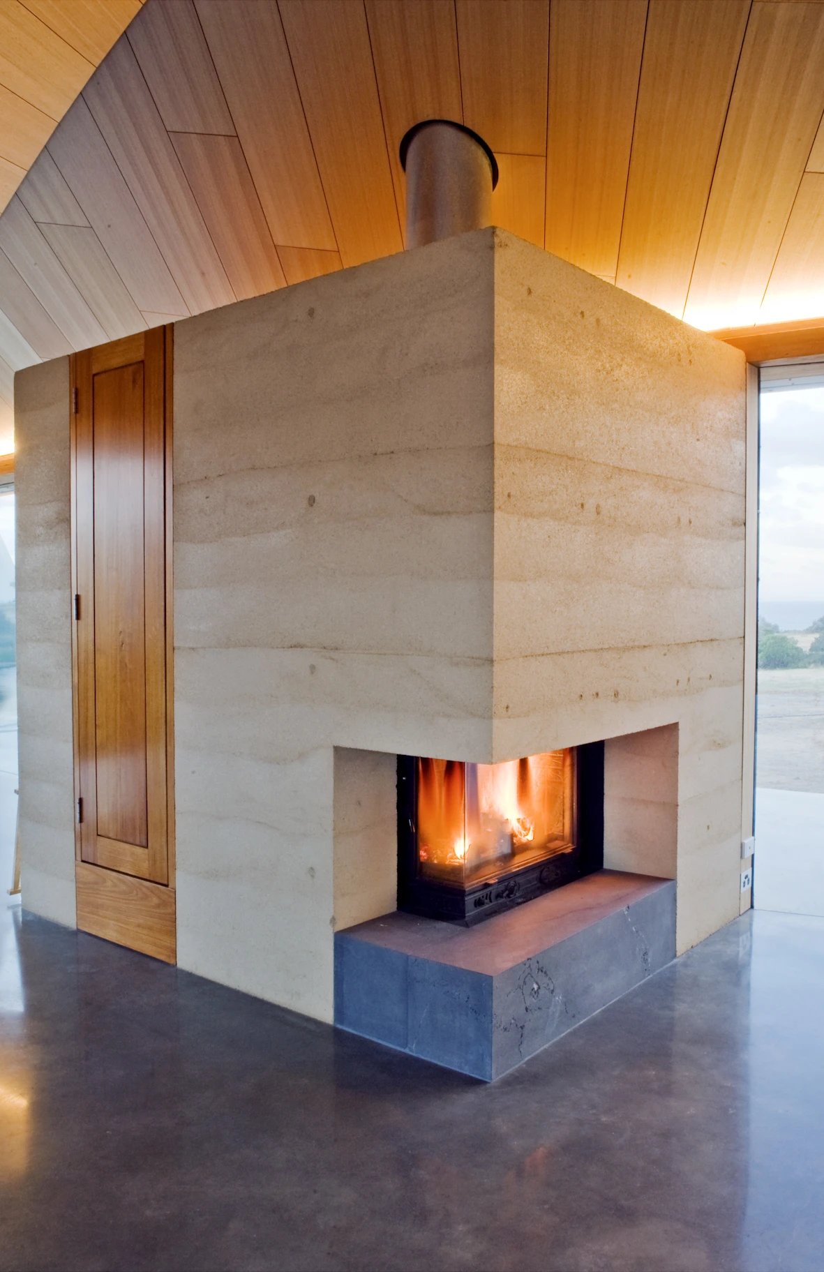 The home’s modern and simple interior finishes include a large central fireplace