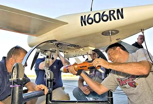 Pyros small tactical munition being mounted on the drop rail of a Cobra UAV