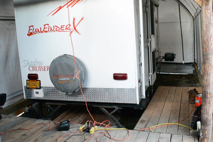 The trailer is parked inside the cabin/carport