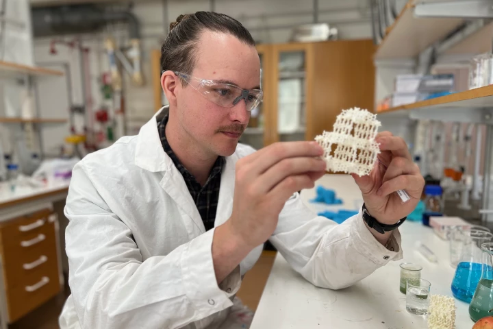 Stockholm University PhD student Erik Svensson Grape with a model of the pomegranate-derived SU-102 molecule
