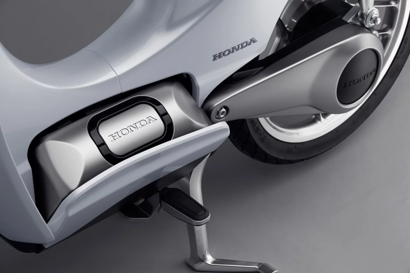 A tilting cover reveals the removable battery of the Honda EV-Cub