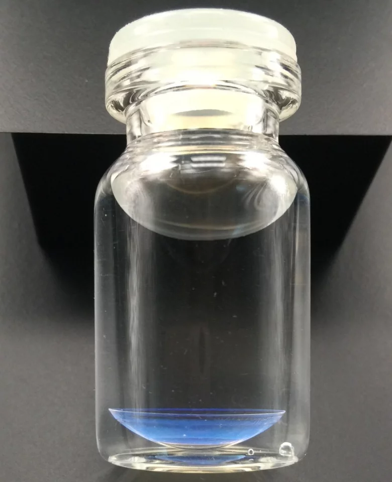 One of the prototype color-changing contact lenses, in the bottom of the flask
