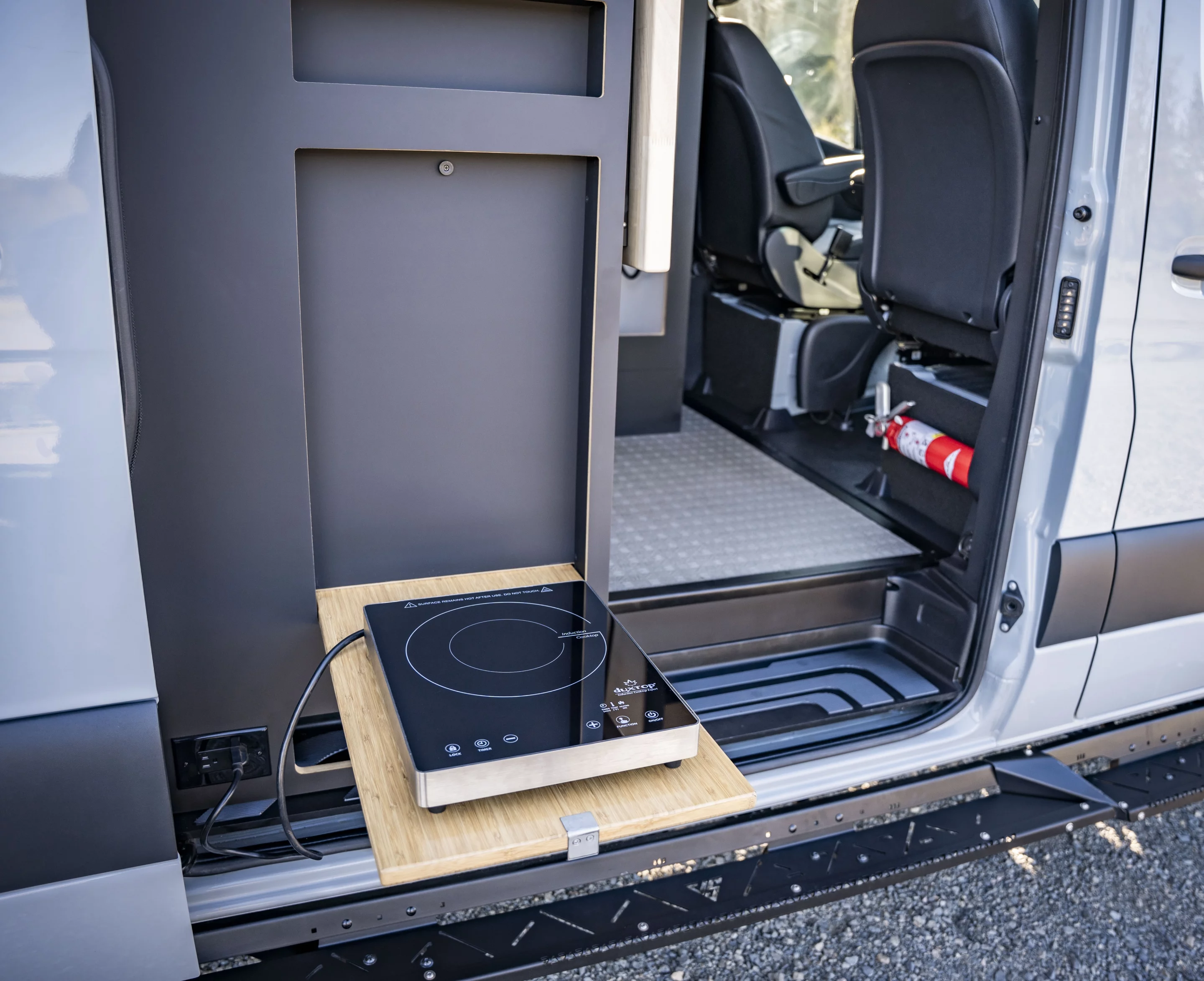 A single-burner portable induction cooktop and strategically placed electric outlets make for versatile indoor/outdoor cooking