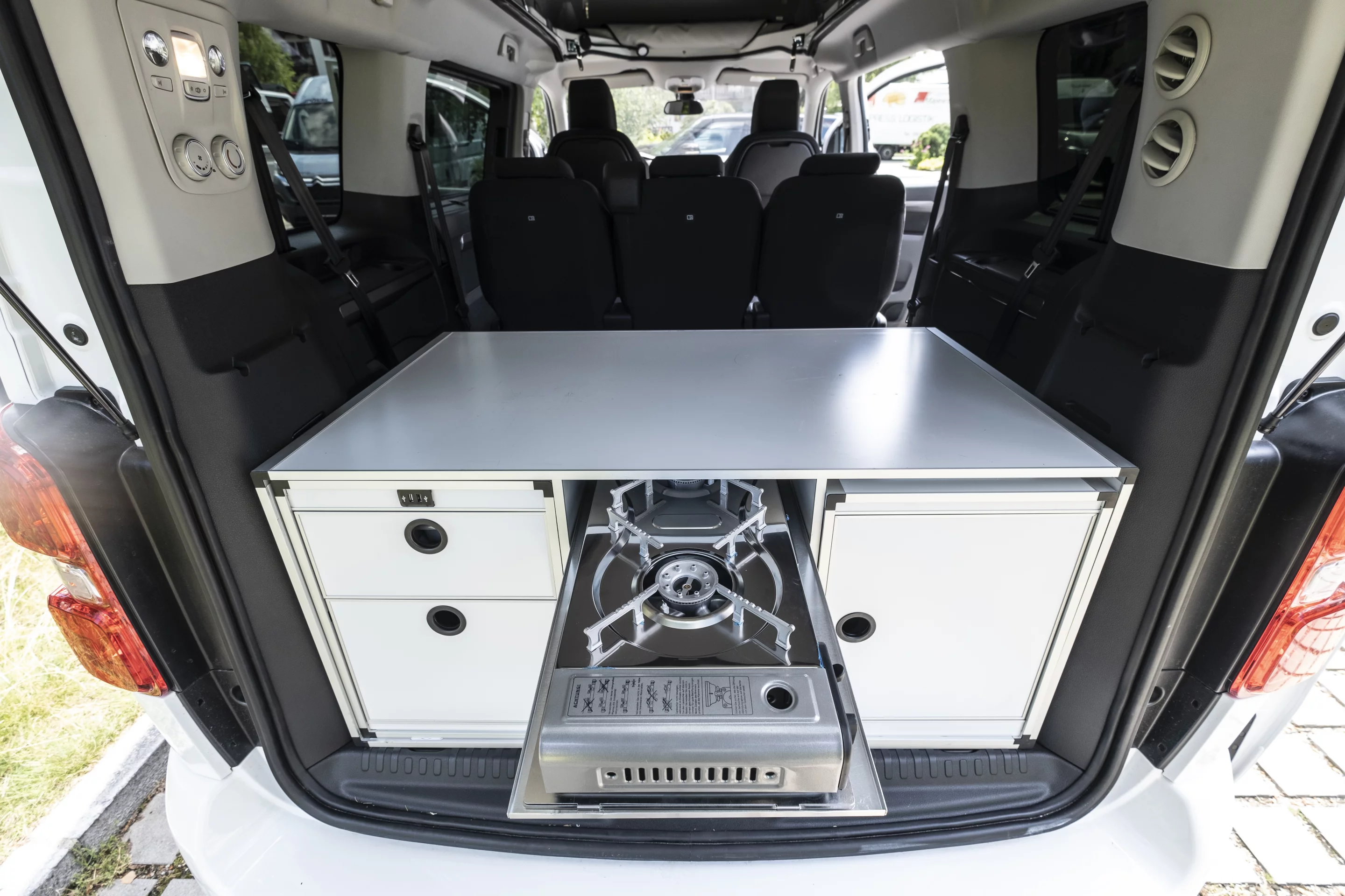 The center Campbox compartment includes an upper slide-out for the two-burner stove, lower slide-out for the fridge/cooler