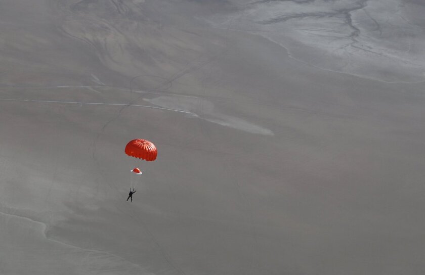 Pilot Pete Siebold as he parachutes safely down to earth after the accident, with his arm up in the air to show everybody that he is alive and well