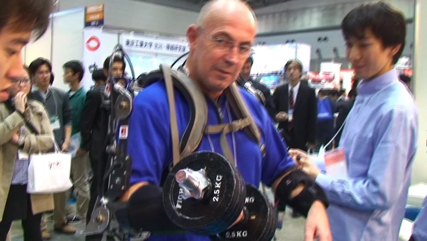 Author Hanlon tries out Koba Labs' muscle suit at iRex in Tokyo