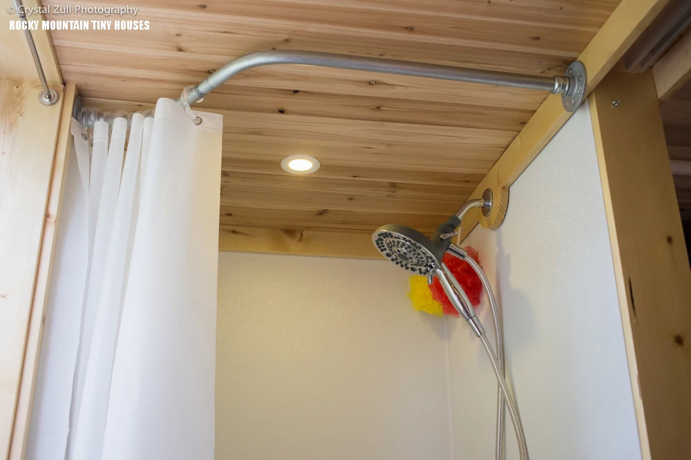 The bathroom sports a shower, sink and a composting toilet