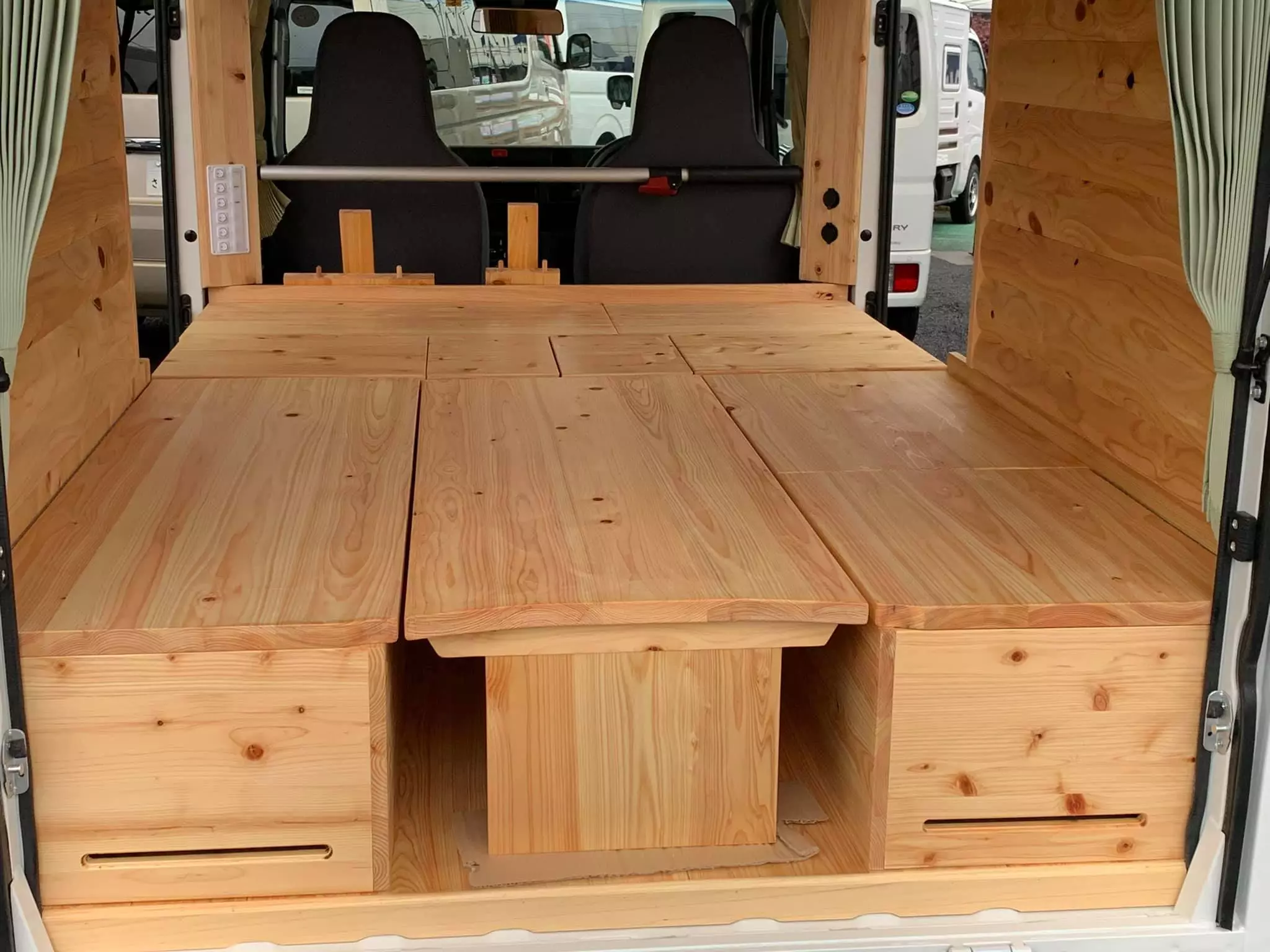 The dining table drops down at night, and the crates fill in the gaps, to create a large bed that fills out most of the interior