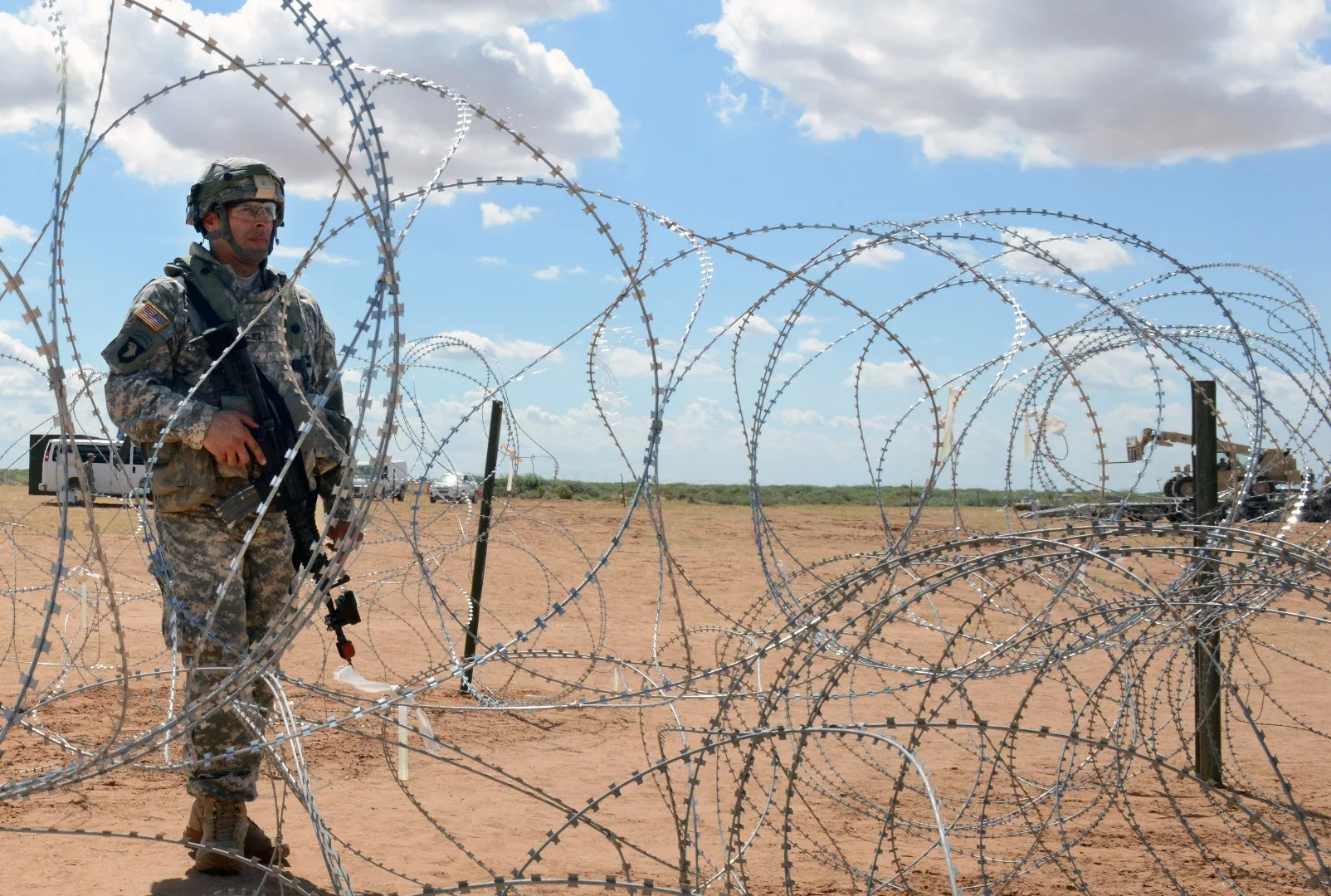 A soldier pulls security, augmenting remotely-controlled multiple weapons systems on the perimeter