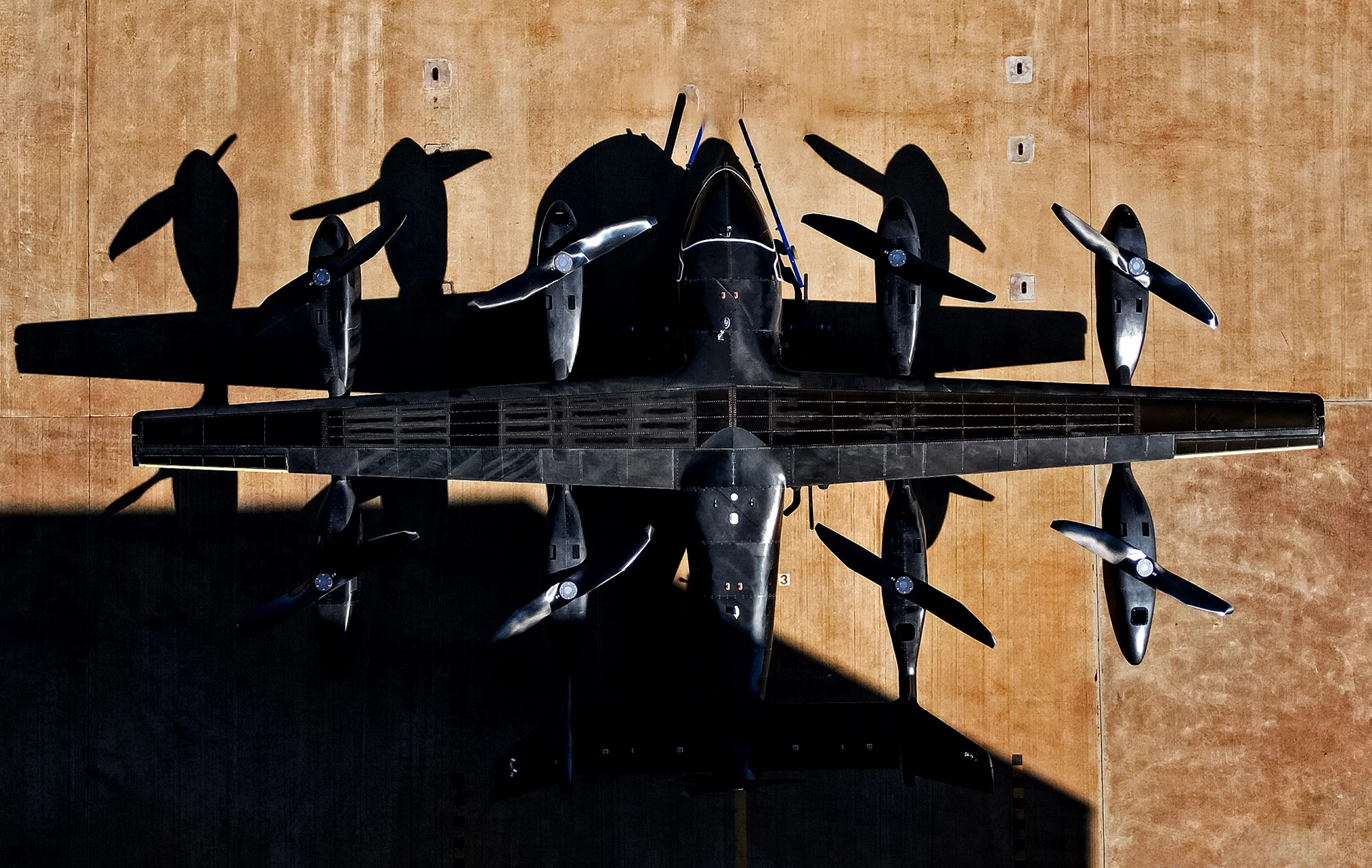 The prototype Eve Air Mobility, top down, partially obscured by shadow
