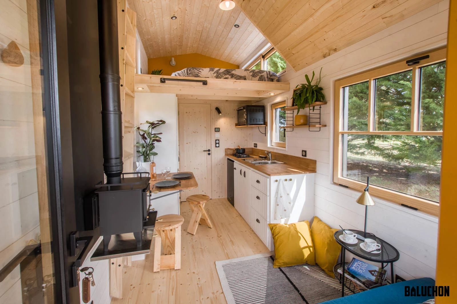 The Miss Twain Tiny House's kitchen includes a fridge, sink, microwave and two-burner propane-powered stove, as well as cabinetry and a large storage area