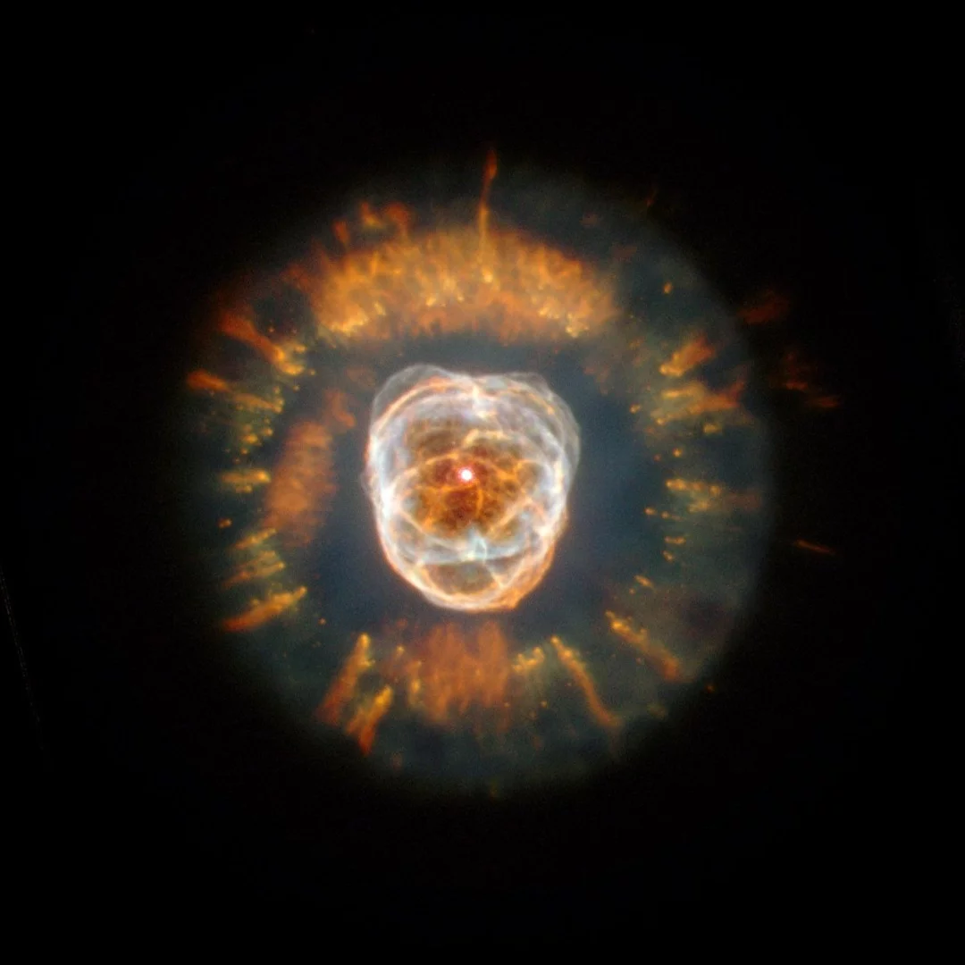 NGC 2392 is nicknamed the Eskimo Nebula, thanks to its apparent resemblance to a face wrapped in a fur parka. The “face” is a bubble of matter being ejected from the dying star in the center, while the “parka” is made up of gas blown off from the outer layer of the progenitor star.