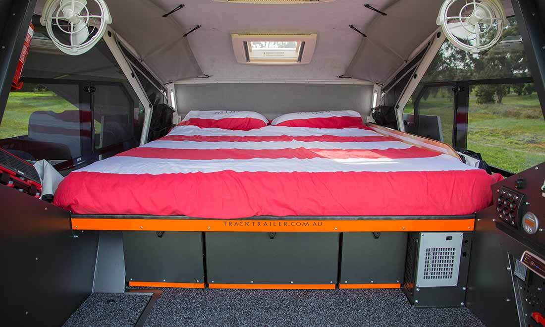 The interior includes a queen bed, sliding windows with screens and roof ventilation